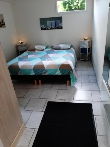 a bedroom with a bed and a tiled floor at tres beau gite ,une ou deux personnes, super équipé 25m2 in Nogent-sur-Seine