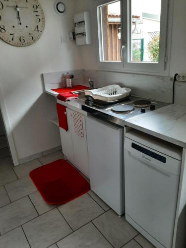 a kitchen with a stove and a clock on the wall at tres beau gite ,une ou deux personnes, super équipé 25m2 in Nogent-sur-Seine