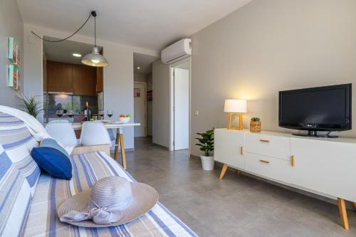 a living room with a bed and a tv at Apartamentos Estival Park in La Pineda