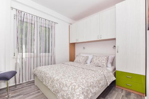 a bedroom with a bed and a large window at Apartment Maslina in Makarska