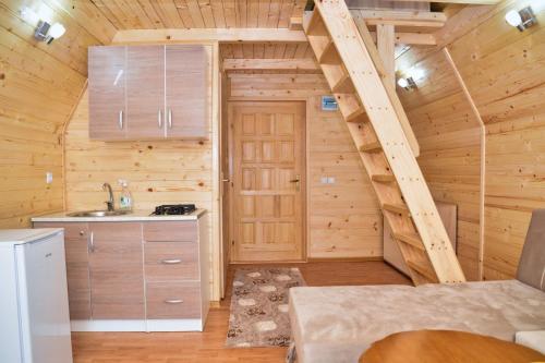 a kitchen with a staircase in a log cabin at Malena Plivsko Jezero Jajce in Jajce