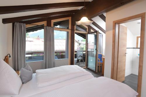 a bedroom with a white bed and a large window at Ferienwohnungen Brigitte in Oberstdorf