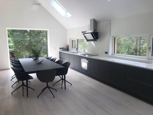 a kitchen with a black table and chairs and a counter at An Caisteal chalet in Crianlarich