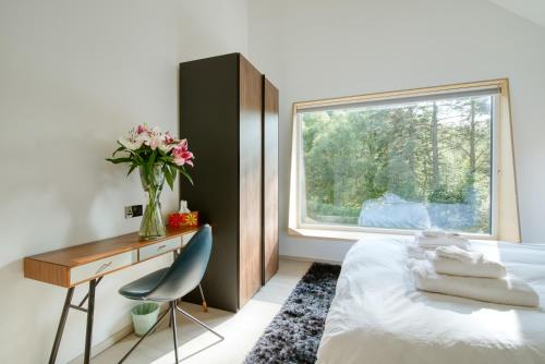 a bedroom with a bed and a desk and a window at An Caisteal Lodge with cascading waterfall view in Crianlarich