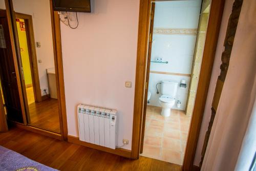 a bathroom with a toilet and a mirror at Hotel Palacio Atxega in Usúrbil