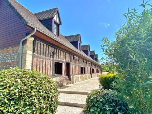 an old building with a walkway leading to a building at chambres et gites d'étretat in Étretat