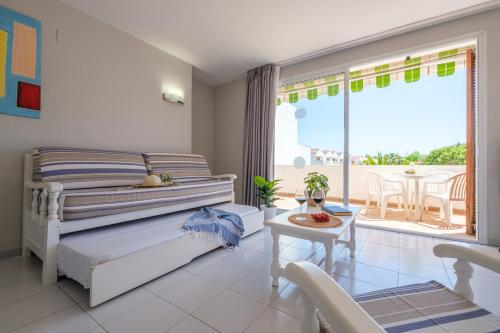 a bedroom with a bed and a table and a balcony at Apartamentos Estival Park in La Pineda