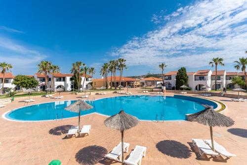 a swimming pool with chairs and umbrellas at Apartamentos Vistapicas in Cala en Blanes