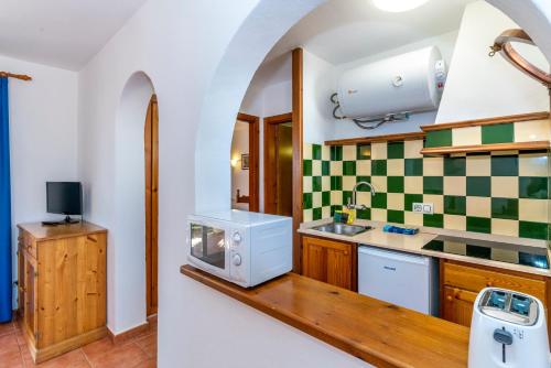 a kitchen with a sink and a microwave at Apartamentos Vistapicas in Cala en Blanes