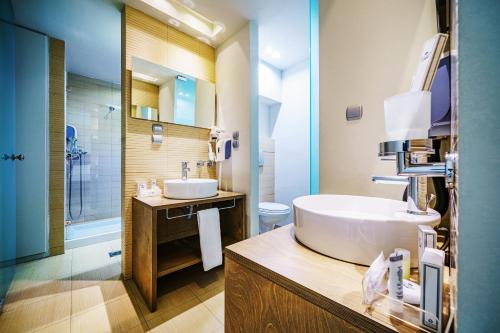 a bathroom with a sink and a toilet and a tub at Capsis Hotel Thessaloniki in Thessaloniki