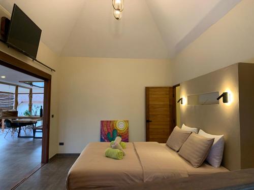 a bedroom with a bed with a teddy bear on it at Baan Taolili villa 3 bedrooms in Hinkong