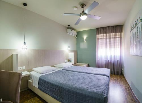 a bedroom with a bed and a ceiling fan at Capsis Hotel Thessaloniki in Thessaloniki