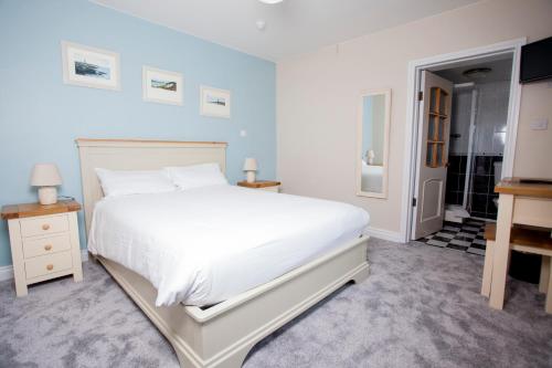 a bedroom with a large white bed and a bathroom at Fort Conan Hotel in Duncannon