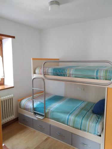 two bunk beds in a room with a window at Vivienda Benasque Ibonet in Benasque