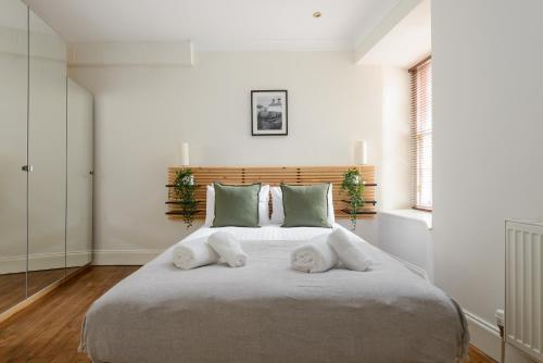 a bedroom with a large bed with towels on it at The West Bow Apartment in Edinburgh