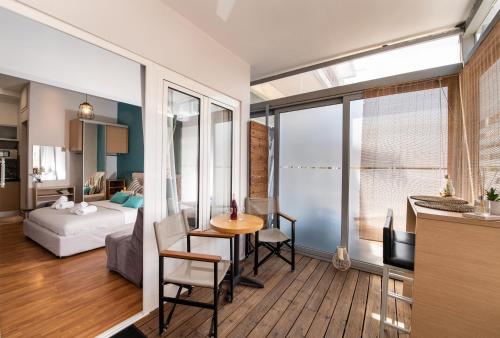 un soggiorno con letto e tavolo in una camera di LEFKAS CITY APARTMENTS & Suites a Città di Lefkada