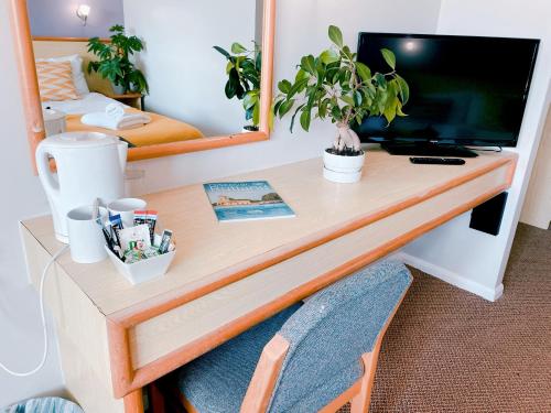 a desk in a room with a television and plants at Redwings Lodge Rutland in Uppingham