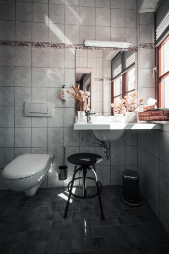 a bathroom with a sink and a toilet and a mirror at Sommers Hotel Altes Posteck in Reichenbach im Vogtland