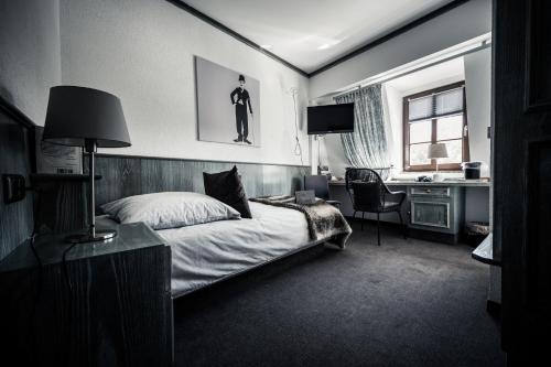 a bedroom with a bed and a desk and a sink at Sommers Hotel Altes Posteck in Reichenbach im Vogtland