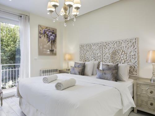 una camera da letto con un grande letto bianco con due cuscini sopra di Sitges Spaces Mediterranean Apartments 5 Bedrooms, 4 Bathrooms, 75M2 Terrace, Centre Sitges- Sleeps 11 a Sitges