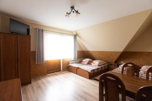 a living room with a bed and a table at U Haliny in Biały Dunajec