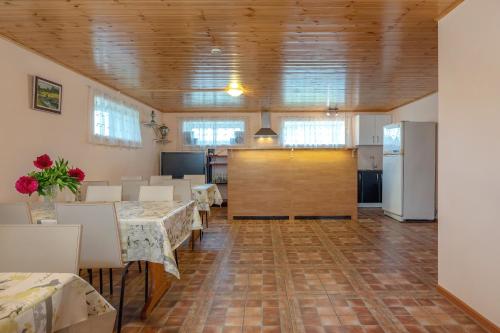 a large room with tables and chairs and a kitchen at Karumetsa Apartment in Otepää