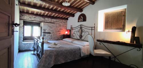 a bedroom with a bed and a stone wall at Helikon -la dimora del viandante- in Montalbano Elicona