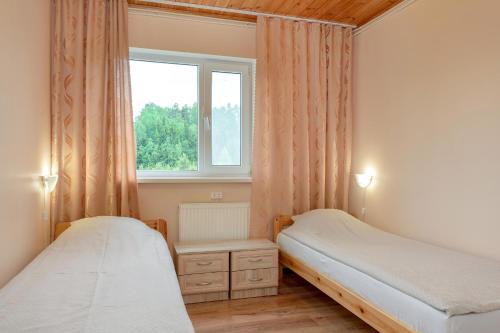 a bedroom with two beds and a window at Karumetsa Apartment in Otepää