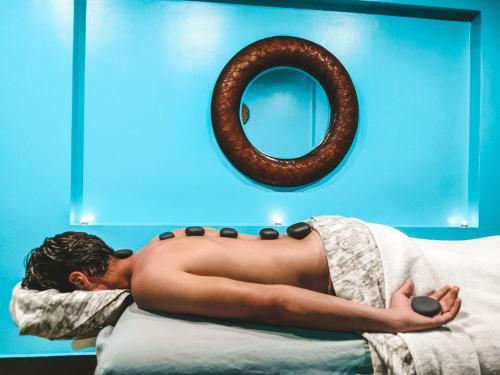a shirtless man laying on a bed with a pretzel at Shana by the Beach Manuel Antonio in Manuel Antonio