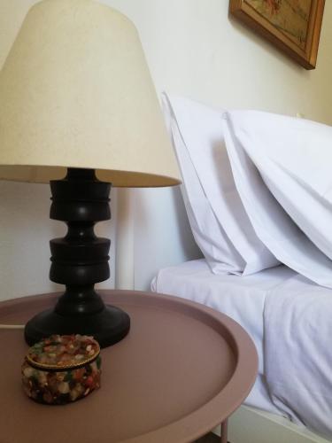 a lamp on a table next to a bed at Olea Home in Agia Pelagia Chlomou