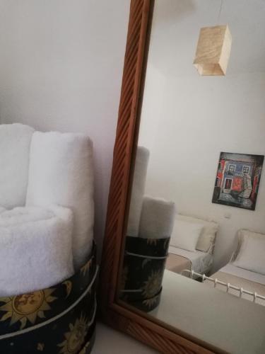a mirror and a stack of towels in a room at Olea Home in Agia Pelagia Chlomou