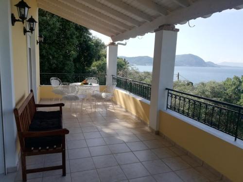 a balcony with a table and chairs and a view of the ocean at Olea Home in Agia Pelagia Chlomou