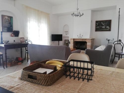 a living room with a table with bananas in a basket at Olea Home in Agia Pelagia Chlomou