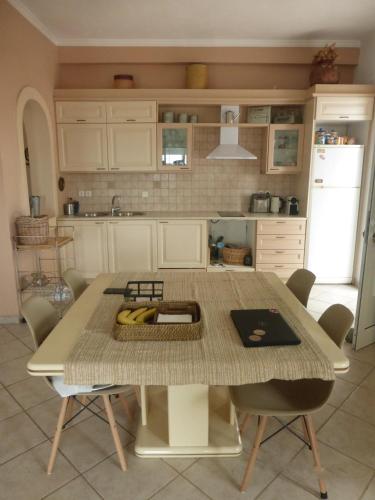 a kitchen with a table with bananas on it at Olea Home in Agia Pelagia Chlomou