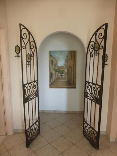 two iron gates in a hallway with a painting at Olea Home in Agia Pelagia Chlomou