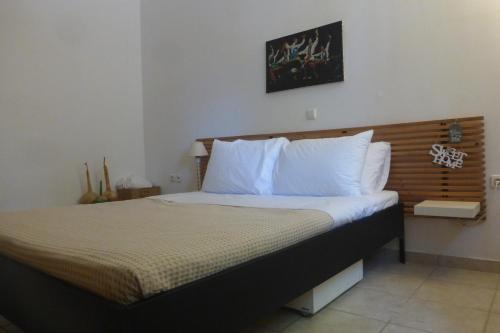 a bedroom with a large bed with white pillows at Olea Home in Agia Pelagia Chlomou