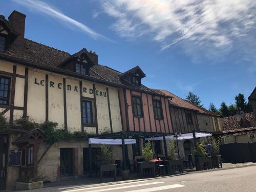 ein Gebäude auf einer Straße mit Tischen davor in der Unterkunft Auberge du Renard'eau in Bèze