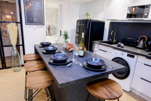 une cuisine avec une table avec des assiettes et des verres à vin dans l'établissement Le Joyau Alsacien - Centre historique, à Sélestat