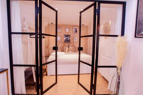 セレスタにあるLe Joyau Alsacien - Centre historiqueのガラスのドアが付いたベッドのある寝室のある部屋