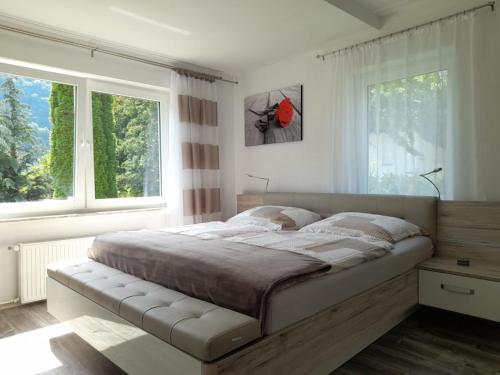 a bedroom with a large bed and two windows at Ferienwohnung Nesa in Traben-Trarbach