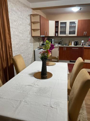 uma cozinha com uma mesa com um vaso de flores sobre ela em House Tuscany em Saraievo