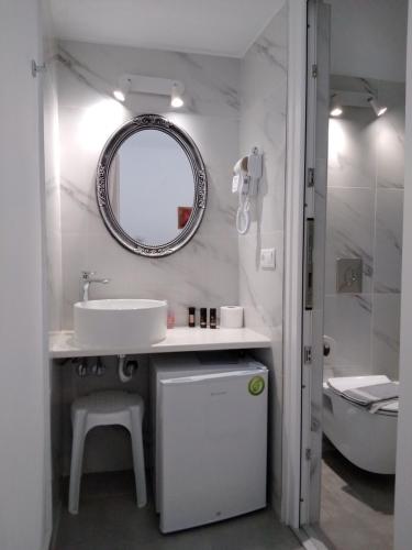 a bathroom with a sink and a mirror and a tub at Asteri Hotel in Ornos