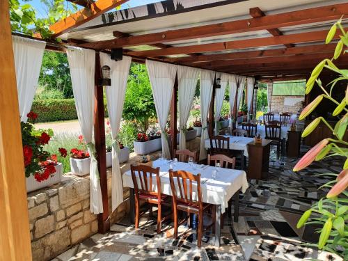 a restaurant with white tables and chairs on a patio at Sobe Sole in Umag