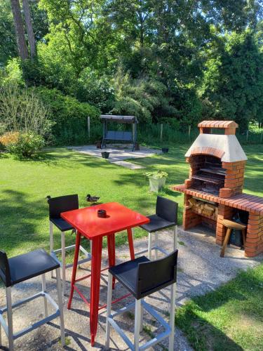 a red table and chairs next to a fire place at chambres et gites d'étretat in Étretat