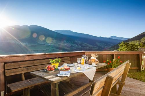 a wooden table with food on top of a deck at Hotel Gasthof Handl in Schönberg im Stubaital