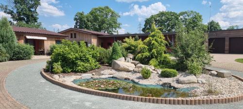 a garden with a pond in front of a house at Ranč Orlice in Třebechovice pod Orebem