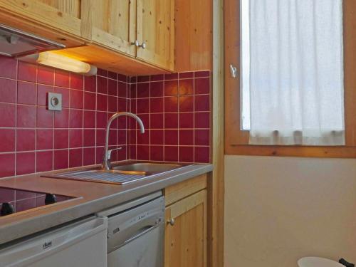 a kitchen with a sink and red tiles at Appartement Méribel, 2 pièces, 4 personnes - FR-1-182-201 in Les Allues