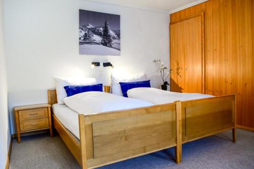 グリンデルワルトにあるFirst Lodgeのベッドルーム1室(ベッド2台、木製キャビネット付)