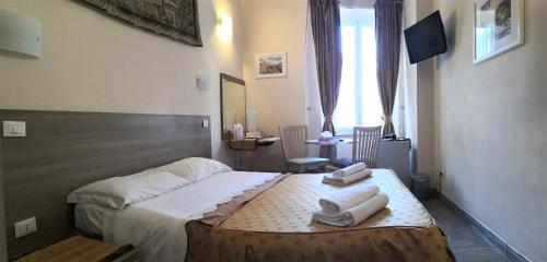 1 dormitorio con 1 cama con 2 toallas en Napoleone Suite en Roma
