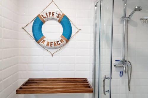 ミアミ・プラトーヤにあるNEW! Modern apartment right on the beach!の壁にライフガードのサインがあるシャワー付きのバスルーム